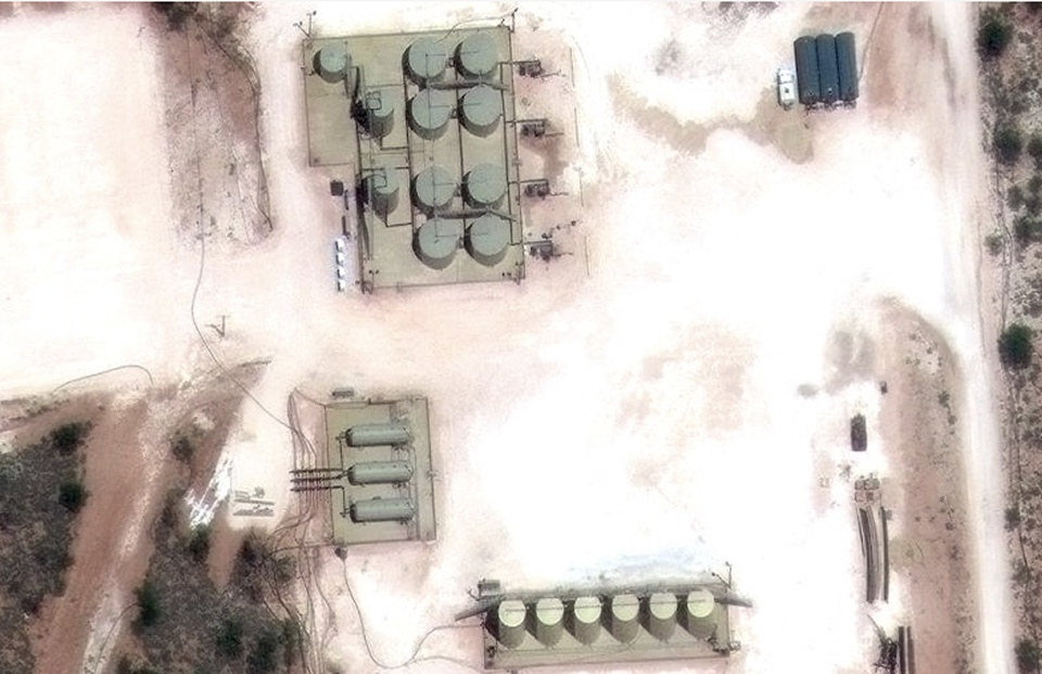 High-resolution aerial view of an industrial or energy facility with multiple storage tanks, buildings, and vehicles, illustrating the level of detail achievable through custom satellite imagery tasking.