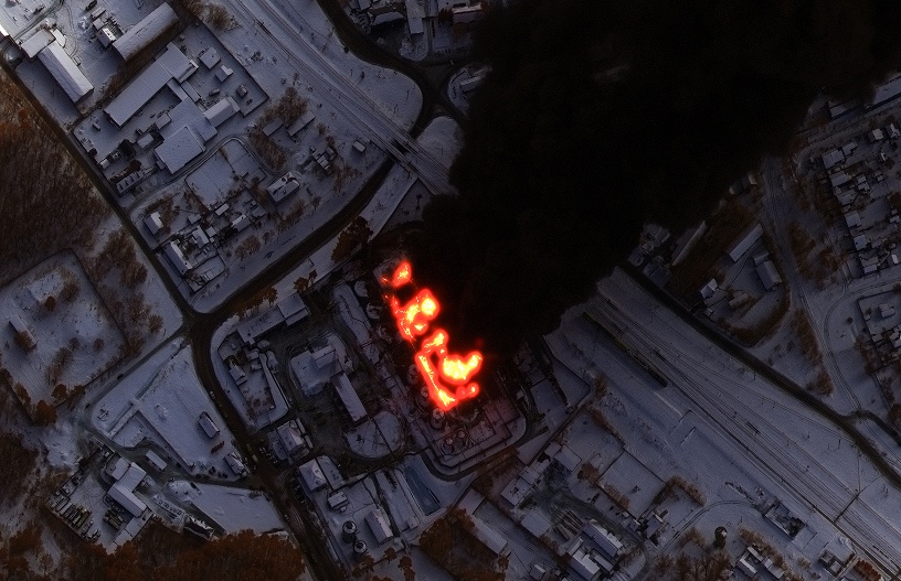 Satellite view of an industrial facility at night with visible thermal anomalies (red areas indicating potential heat or emergencies), illustrating risk mitigation through condition monitoring.