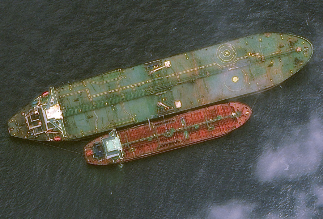 Aerial view of two oil tankers anchored in dark water, illustrating offshore asset monitoring for regulatory compliance and risk mitigation.